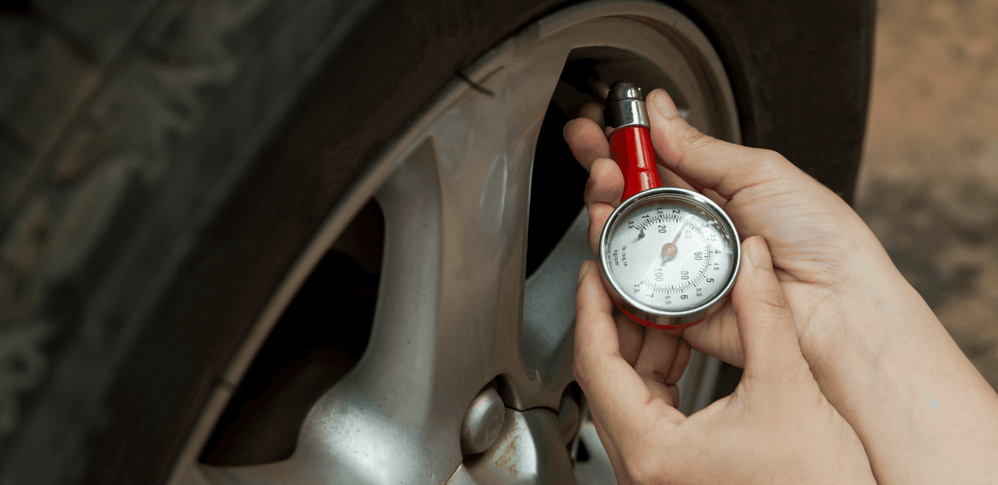 Pomiar ciśnienia w oponie samochodowej za pomocą ręcznego manometru analogowego – kontrola stanu technicznego koła.