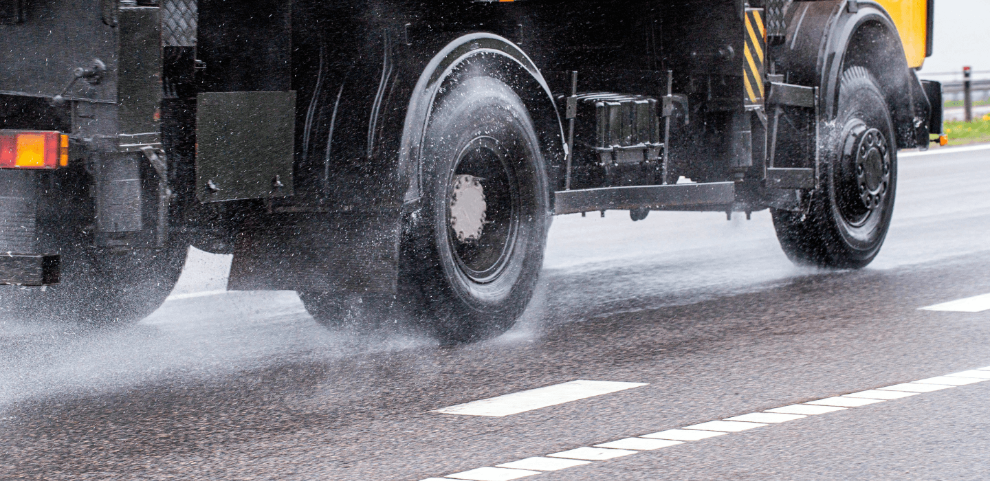Koła ciężarówki jadącej po mokrej nawierzchni autostrady – odprowadzanie wody przez opony ciężarowe (zjawisko aquaplaningu).