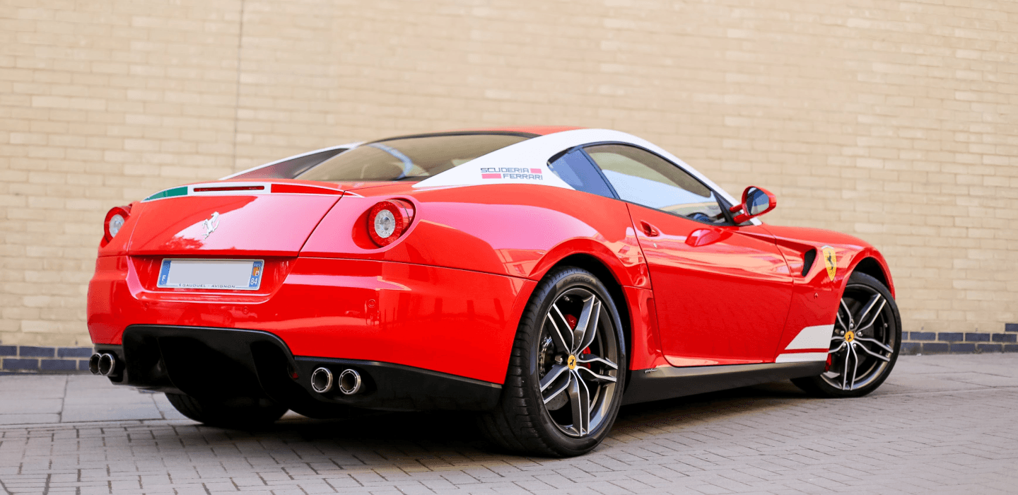 Czerwone sportowe Ferrari Scuderia z widocznym niskoprofilowym ogumieniem Pirelli P Zero na tylnej osi.
