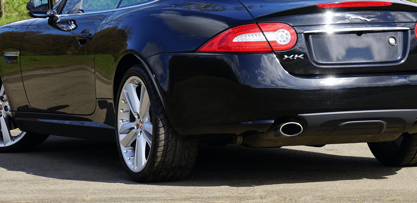 Tył czarnego Jaguara XK z szerokimi oponami sportowymi – stabilność przy wysokich prędkościach.
