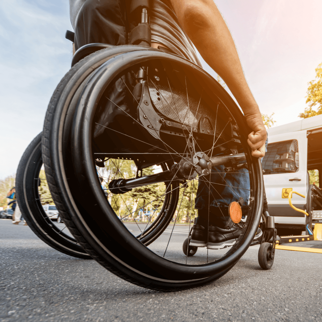 Osoba na wózku inwalidzkim podjeżdżająca do rampy busa – wąskie opony do wózków inwalidzkich.