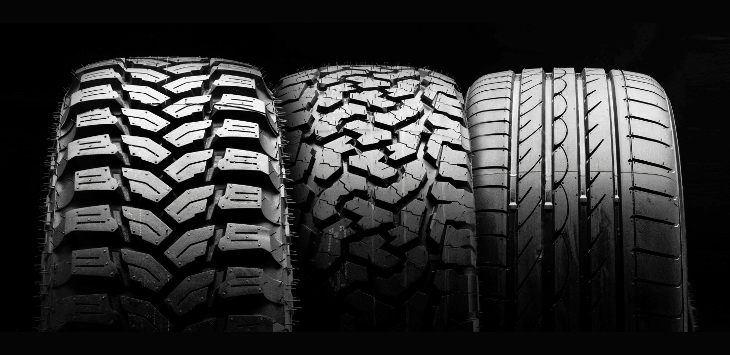 Porównanie trzech typów bieżników opon: terenowa MT, uniwersalna AT oraz szosowa opona letnia na czarnym tle.