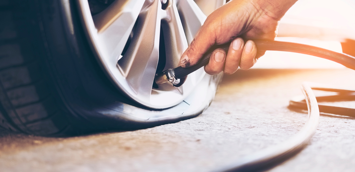 zdjęcie mechanika niosącego nowe opony samochodowe
