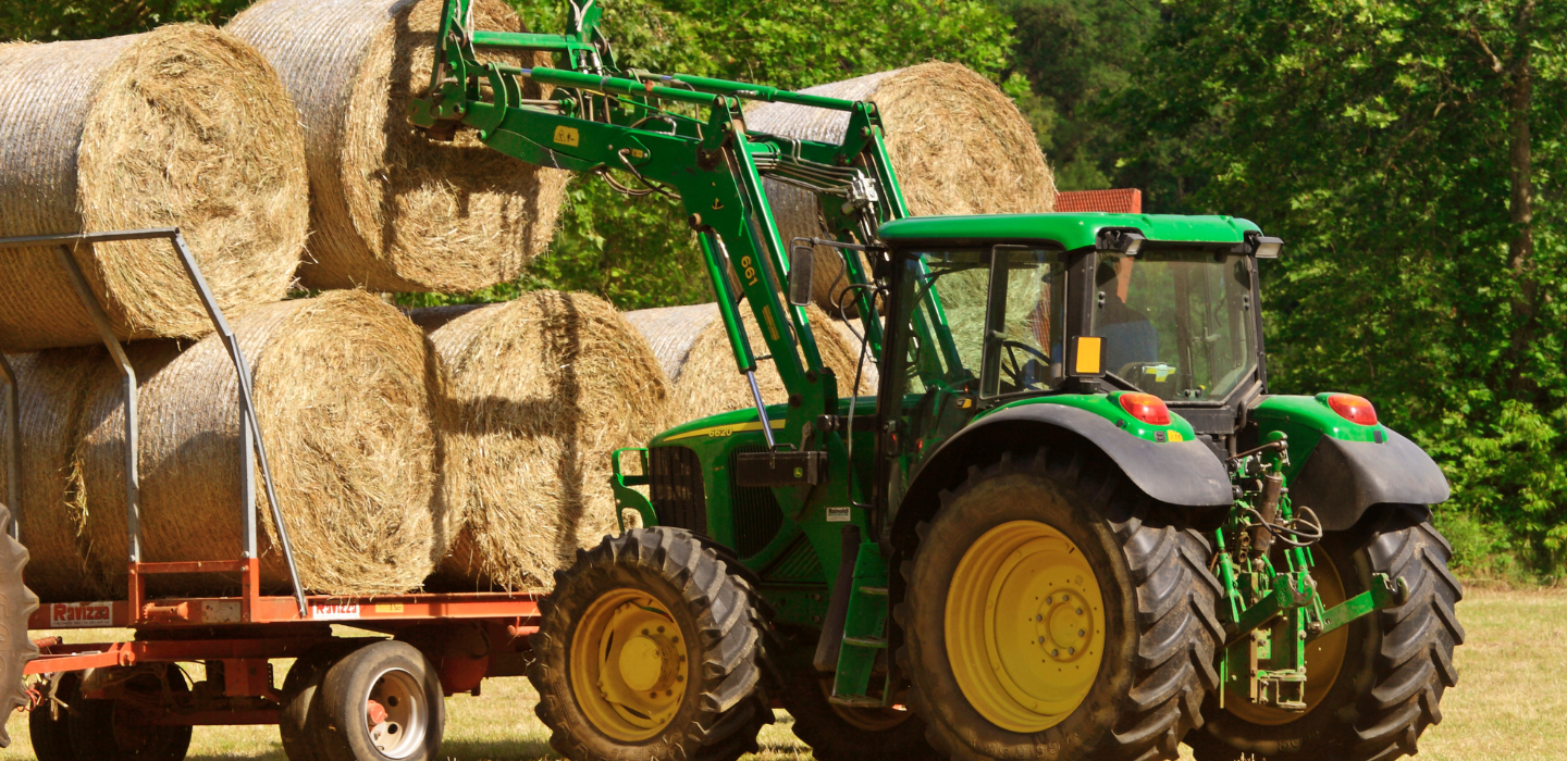 zdjecie traktora podnoszącego bale słomy